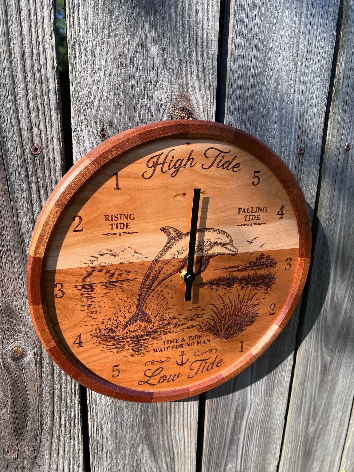 Angled view of the dolphin tide clock showing the segmented sapele ring
